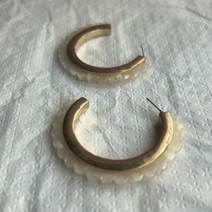 Gold toned hoop earrings with a scalloped edge